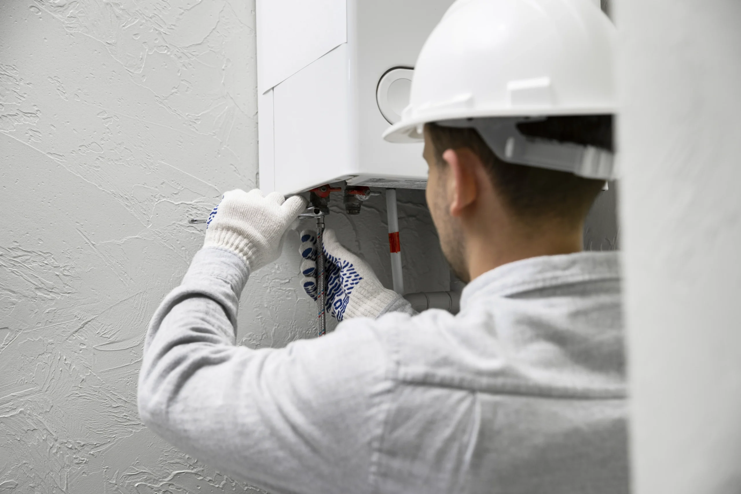 worker-repairing-water-heater commercial water heater installation
